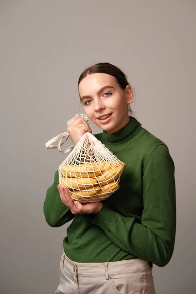 Mujer Joven Sosteniendo Bolsa Cuerda Con Plátanos Interior Del Hogar — Foto de Stock