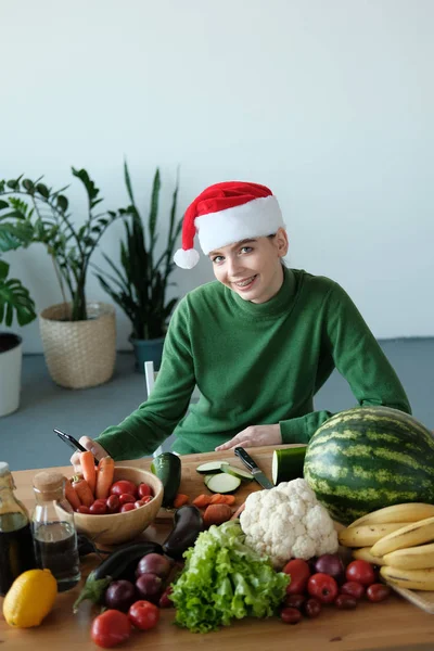 Ung Kvinna Santa Hatt Med Telefon Köksbordet Med Grönsaker Heminredning — Stockfoto