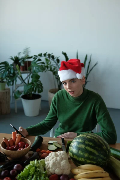 Ung Kvinna Santa Hatt Med Telefon Köksbordet Med Grönsaker Heminredning — Stockfoto