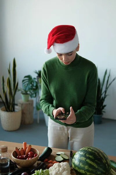 Young Girl Santa Hat Taking Photo Fresh Vegetables Home Interior — Stock Photo, Image