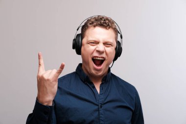 düz arka plan karşı kulaklık ile heyecanlı adam stüdyo portresi
