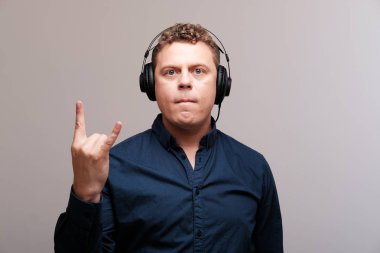 düz arka plan karşı kulaklık ile heyecanlı adam stüdyo portresi