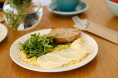 kahve dükkanında kahvaltı için arugula ve peynir ile omlet servis