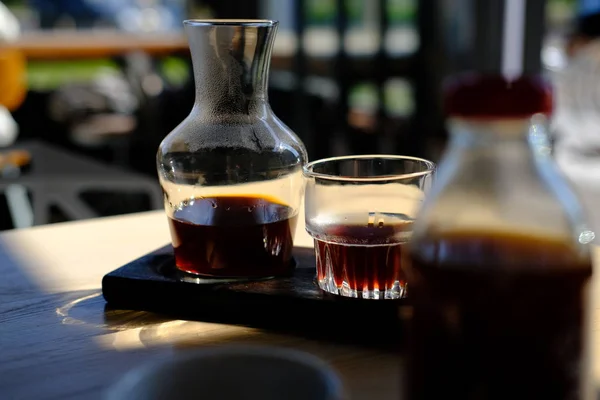 jug and glass of fresh cold brewed black coffee on cafe table