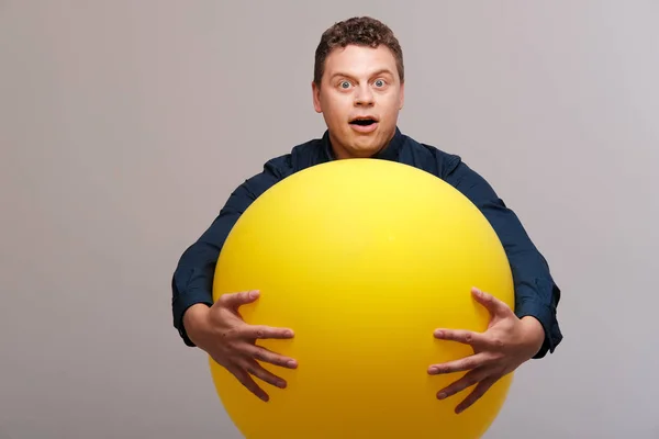 Retrato Estúdio Homem Posando Com Grande Bola Amarela Contra Fundo — Fotografia de Stock