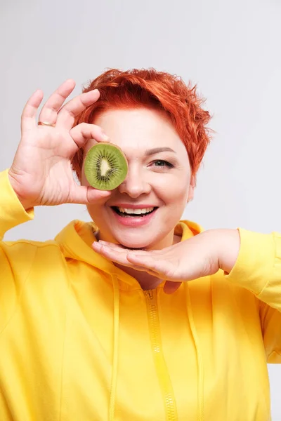 Studio Portrait Redhead Woman Yellow Hoodie Covering Eye Kiwi Fruit — 스톡 사진