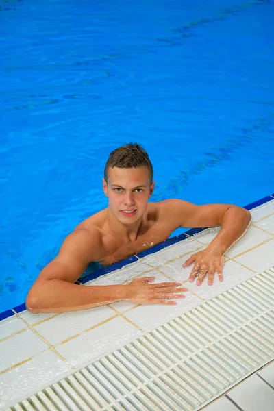 屋内スイミングプールの水からカメラを見て若い男性水泳選手 — ストック写真