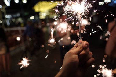 Elinde şen kıvılcım tutan kişinin yakın çekim