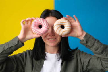Oyuncu kız mavi ve sarı arka planda donut yapıyor.