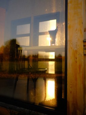 Güneş ışığı pencereye yansıyor. Gün batımı güneşi. İç detay