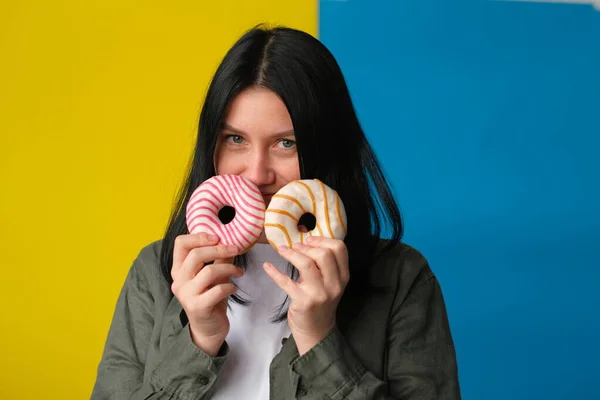 Улыбающаяся Женщина Пончиками Синем Желтом Фоне — стоковое фото