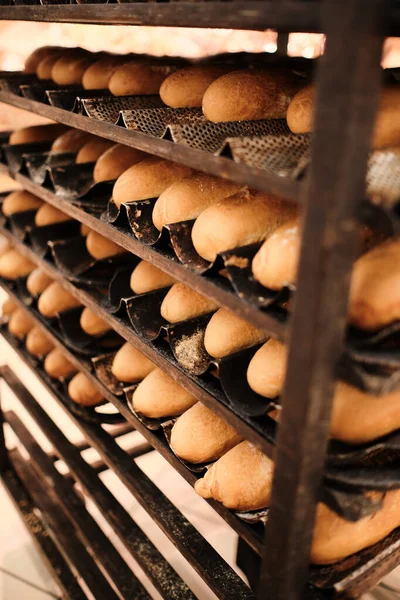 Rack with long loaves close-up pastries bakery production.