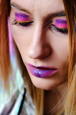 20-25 yaşlarında, parlak makyajlı ve mavi gözlü güzel bir kızın yakın plan portresi..