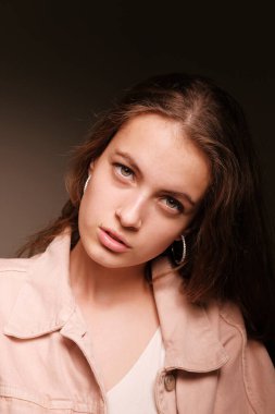 Pembe ceketli kız arka planda poz veriyor. Moda fotoğrafçılığı kavramı