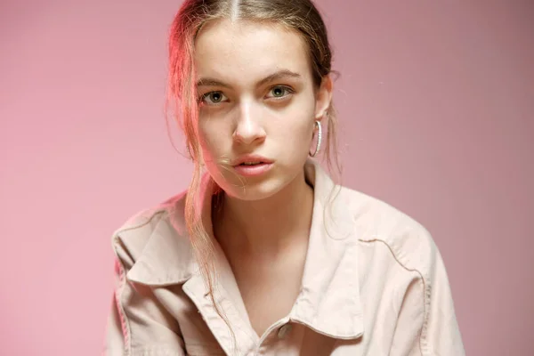 Una chica en un denim rosa muestra diferentes emociones y posa sobre un fondo rosa . —  Fotos de Stock