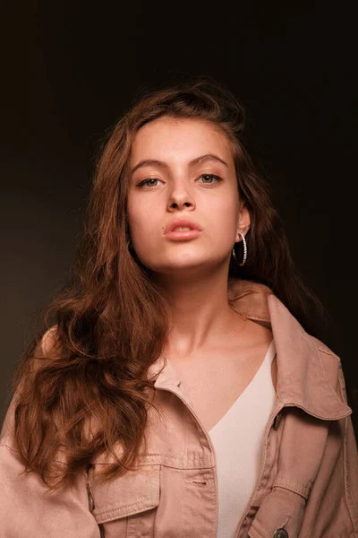 Girl in a pink jacket poses on a dark background. Fashion photography concept — Stock Photo, Image