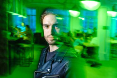 Yeşil ışıklı arka planda izole edilmiş güzel beyaz adam portresi.. 