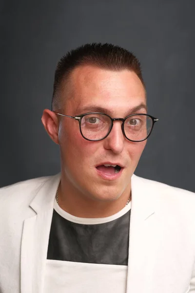 Portrait en gros plan d'un homme de 30 à 35 ans aux cheveux courts, en lunettes de vue et veste blanche — Photo