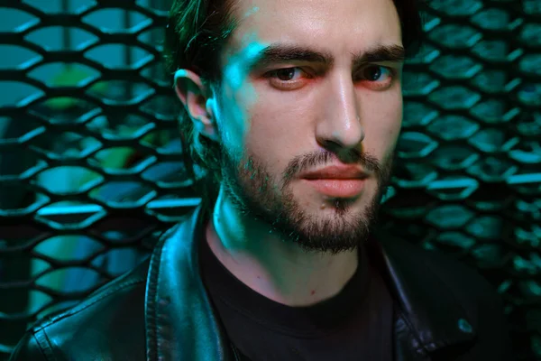 Krásný kavkazský mladý muž portrét izolované na mnohobarevné neonové světlo pozadí. — Stock fotografie