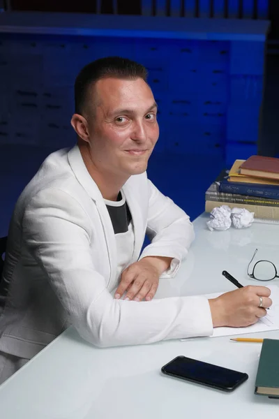 Biznesmen w wieku 30-35 lat w białej kurtce podpisuje ważne dokumenty.. — Zdjęcie stockowe
