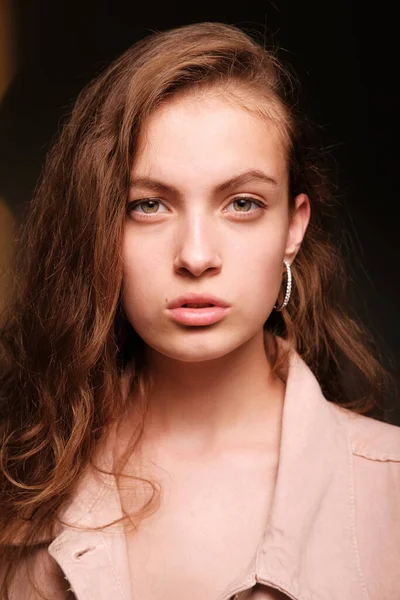 Girl in a pink jacket poses on a dark background. Fashion photography concept — Stock Photo, Image