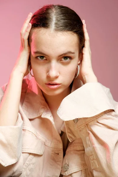 Ένα κορίτσι με ροζ τζιν δείχνει διαφορετικά συναισθήματα και ποζάρει σε ροζ φόντο.. — Φωτογραφία Αρχείου