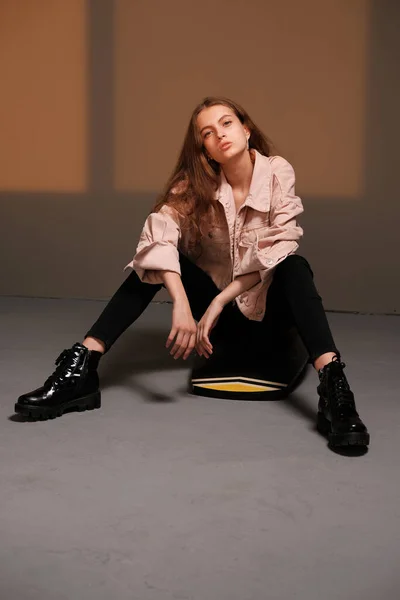 Chica sentada en un tablero de equilibrio y posando. Concepto de fotografía moda — Foto de Stock