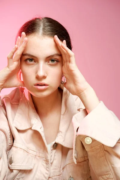Una chica en un denim rosa muestra diferentes emociones y posa sobre un fondo rosa . — Foto de Stock