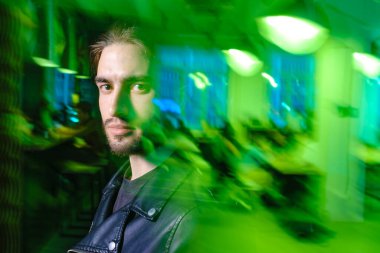 Yeşil ışıklı arka planda izole edilmiş güzel beyaz adam portresi.. 