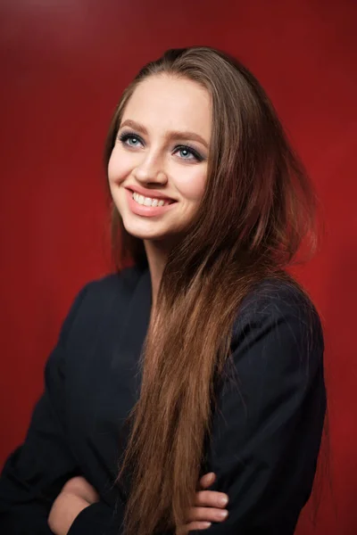 Retrato de una joven hermosa niña de 20-25 años con diferentes emociones en una chaqueta sobre un fondo rojo —  Fotos de Stock