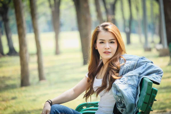 Tayland Asyalı kadın bir T-shirt ve jeans giymiş. Genel parkta mutluyuz