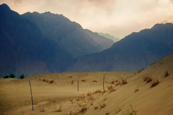 Sunset after sand storm at cold desert in Skardu with layer of mountains behide. Gilgit-Baltistan, Pakistan.