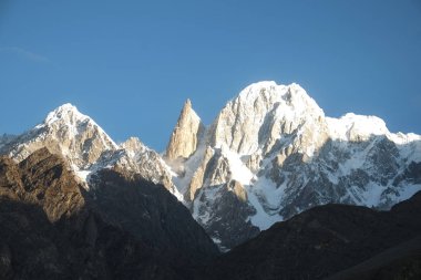 Bayan parmak ve Ultar Sar dağ doruklarına tarafından sabah güneş ışığı yaktı. Hunza Vadisi, Gilgit Baltistan, Pakistan.