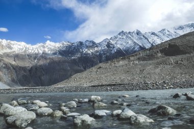 Akan su akışı kar arasında dağlar karakurum aralığındaki şapkalı. Passu, Gilgit-Baltistan, Pakistan.
