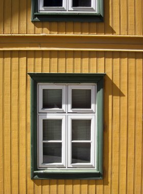 Sarı dil ve oluk duvar ve beyaz windows yeşil çerçeve ile.
