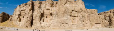 Panoramik Nakş-Rustam kaya kabartmaları uçurumun yüz yüksek kesme dört büyük mezar gösteren. Fars Eyaleti, Iran.