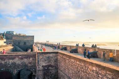 Essaouira, Fas. 11 Mart 2014: Rahatlatıcı Atlantik sahilinde sahil surları etrafında insanlar.
