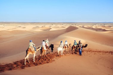 Sahara Çölü'nde deve karavan ile zevk turistler. Erg Shebbi, Merzouga, Fas.