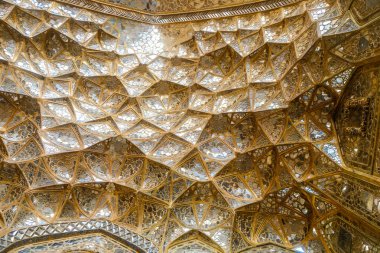 Çehel Sotoun Sarayı'nın girişinde ayna çalışma ile atlama dekoratif altın mukarnas dokusuna tavan. Isfahan, Iran.