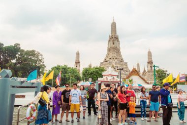 Bangkok, Tayland. 30 Aralık 2018: Grup çeşitli gezginler Wat Arun iskele, Chao Phraya Nehri bir teknede bekleyen duba üzerinde duruyor. Saldırın Wat Arun pagoda içinde zemin olduğunu.