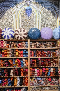 Fez yerel bir dükkanda Satılık deri eşyalar. Renkli Ayakkabı ve poufs bir ahşap raf ürün yelpazesine. Fes el Bali, Fas.