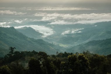 Dağ aralığı, Nanthaburi Milli Parkı etrafında sis ve bulutlar Denizi ile yeşil ormanın havadan görünümü. Nan Province, Tayland.
