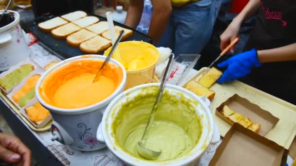 地元のストリートフード市場で販売のためのタイ風味のカスタードトーストを作るアジアのベンダー. — ストック動画