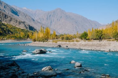 Ghizer vadisinde Hindu Kush sıradağları boyunca akan berrak turkuaz mavisu nehri. Gilgit Baltistan Sonbahar sahne, Pakistan.