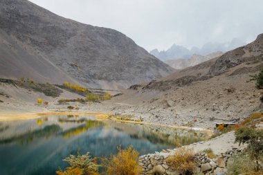 Karakoram dağlarına karşı Borith Gölü 'nün sularındaki yansımanın güzel manzarası. Gulmit Gojal, Hunza Valley 'de sonbahar sezonu. Gilgit Baltistan, Pakistan.