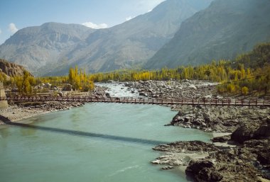 İndus nehri Ghanche bölgesindeki dağlık bölgede akar ve Karakoram dağlarına karşı sonbahar mevsiminde renkli ağaçlar görülür. Gilgit Baltistan, Pakistan.
