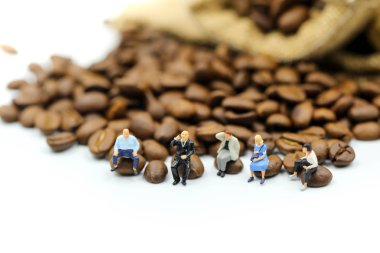 Minyatür insanlar: Kavrulmuş kahvenin Cappuccino gün kavramı için kullanarak üzerinde oturan insanlar.