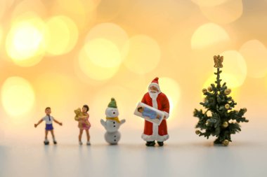 Mutlu Noeller ve mutlu yıllar Minyatür İnsanlar: Noel Baba bebeğiyle çocuklar ve ren geyikleri beyaz arka planda izole edilmiş, Noel festivalinde.