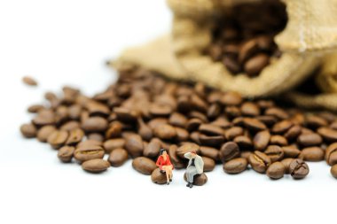 Minyatür insanlar: Kavrulmuş kahvenin Cappuccino gün kavramı için kullanarak üzerinde oturan insanlar.