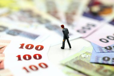 Minyatür insanlar: işadamı para ile ayakta, mali kavramı ve daha fazlasını satın güç.